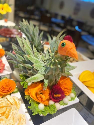 Gran lençóis Flat 2 suítes vista piscina في باريرينهاس: تنسيق الزهور مع طائر في الأعلى