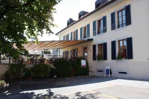 ein Gebäude mit einem Tisch und Stühlen davor in der Unterkunft Auberge Communale à l'Union in Gilly