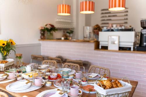a table with plates of food and bread on it at Inselpension Henriette in Norderney