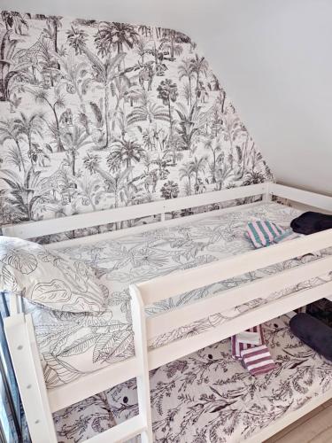 - une chambre avec des lits superposés et du papier peint tropical dans l'établissement Écrin de Seigy, 5 minutes du ZOO de BEAUVAL, à Seigy