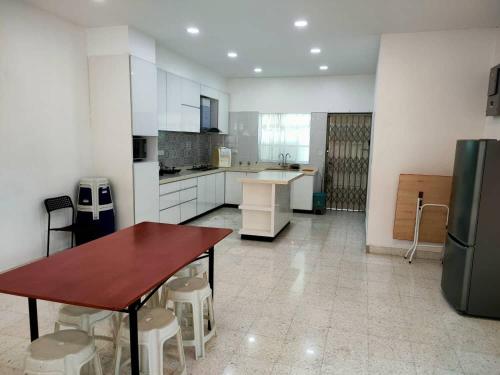una grande cucina con tavolo e frigorifero di Tanjung bungah double story house for 18 people a Tanjung Bungah