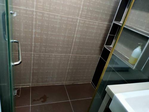 un bagno con doccia con porta in vetro di Tanjung bungah double story house for 18 people a Tanjung Bungah