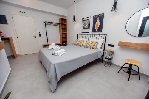 a bedroom with a bed and a table and a mirror at LA PLAZA luxury suites NEA VRASNA in Nea Vrasna