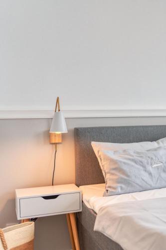 a bed with a nightstand next to a bed with a lamp at Inselpension Henriette in Norderney