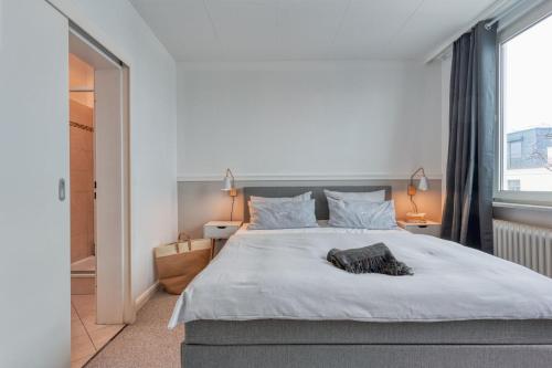 a bedroom with a large white bed and a window at Inselpension Henriette in Norderney