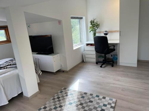 a bedroom with a bed and a desk and a chair at SelVik in Bergen