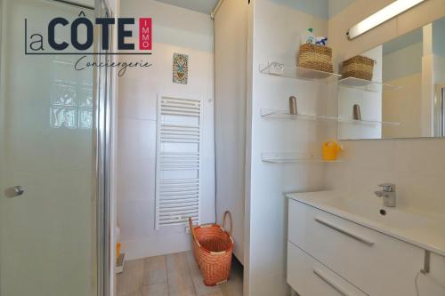 une salle de bain avec un lavabo et un miroir dans l'établissement Le clos du village, à Martigues