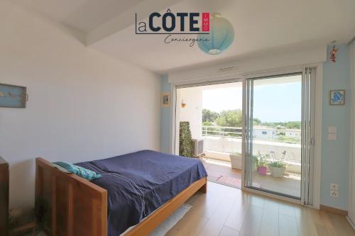une chambre avec un lit et un balcon dans l'établissement Le clos du village, à Martigues