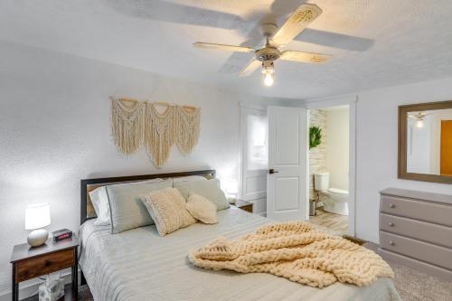 Un dormitorio con una cama y un ventilador de techo. en Ohio Farmhouse Retreat with Fire Pit and Patio, en Monroeville