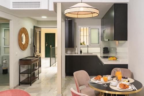 a kitchen and a dining room with a table and chairs at San Clemente House in Seville