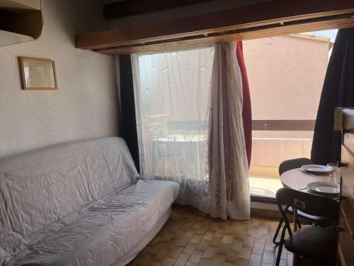 un salon avec un canapé et une fenêtre dans l'établissement Appart Studio mezz 3 couchages PORT LEUCATE NATURISME PL010-731, à Port-Leucate