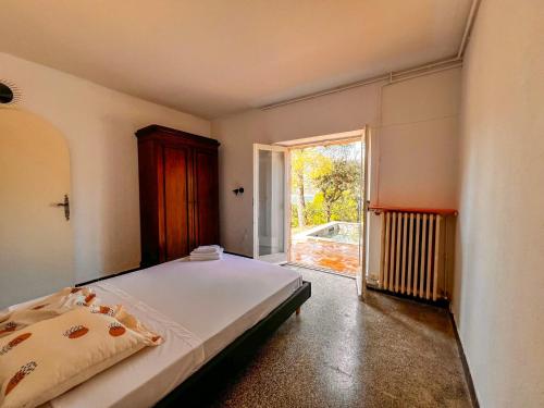 une chambre avec un lit et une grande fenêtre dans l'établissement Charmante Villa Provençale pieds dans l'eau avec piscine et plage privée, à Saint-Raphaël