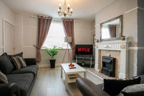 a living room with a couch and a fireplace at Manvers House, Rotherham for contractors, Families, free parking, Spacious, WIFI, modern in Wath upon Dearne