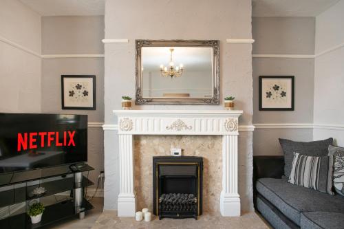 a living room with a fireplace with a mirror at Manvers House, Rotherham for contractors, Families, free parking, Spacious, WIFI, modern in Wath upon Dearne