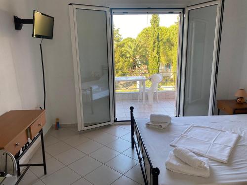 a bedroom with a bed and a view of a patio at Pefki Apartment 6 in Artemísion