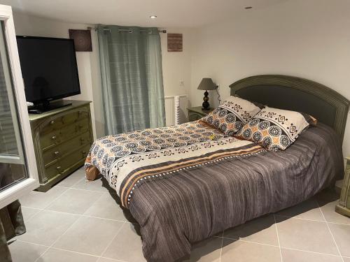 - une chambre avec un lit et une télévision sur une commode dans l'établissement Villa bord de mer deux ch sdb privative, à Agde
