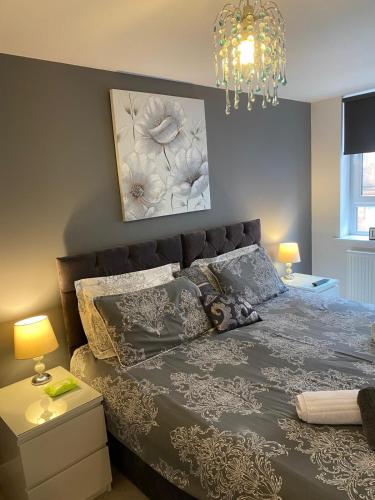 a bedroom with a bed and a chandelier at Mossie Apartment in Ayr