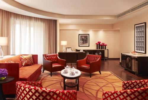 a living room filled with furniture and a red couch at Taj Santacruz in Mumbai