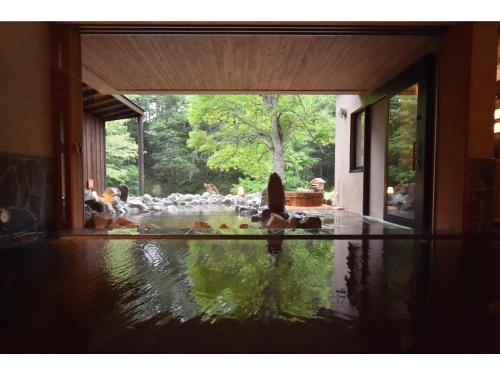 a living room with a pool of water in a house at La Vista Akangawa in Akankohan