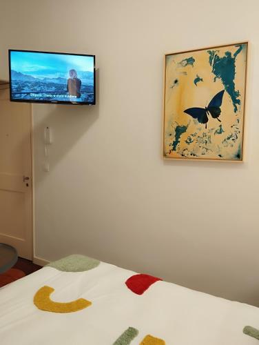 a flat screen tv hanging on a wall with a bed at Bella Vista in Funchal