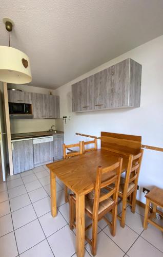 une cuisine avec une table et des chaises de salle à manger en bois dans l'établissement 1 Bedroom appt with beautiful views, à Les Deux Alpes