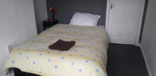 a bed with a brown pillow on top of it at Sports City Guest House in Manchester
