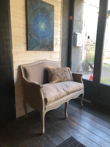 a chair with a pillow on it in a room at le 25bis in Saint-Martory