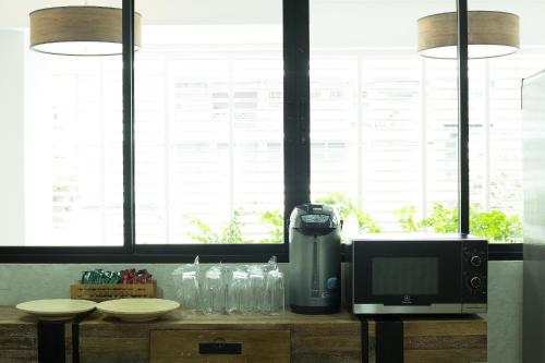 a kitchen with a microwave and a television on a counter at Thanabhumi in Bangkok