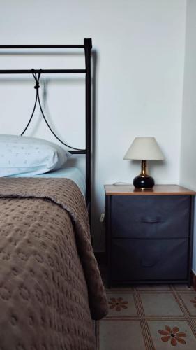 a bedroom with a bed and a lamp on a nightstand at Eco House San Michele in San Michele