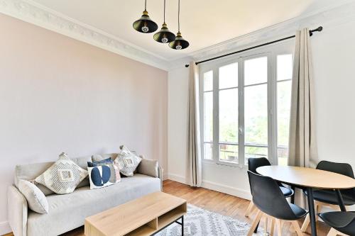 un salon avec un canapé et une table dans l'établissement Appartement Spacieux et paisible Magnifique Vue, à Puteaux