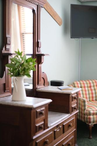 a living room with a dresser with a plant on it at Terrace Inn and 1911 Restaurant in Petoskey