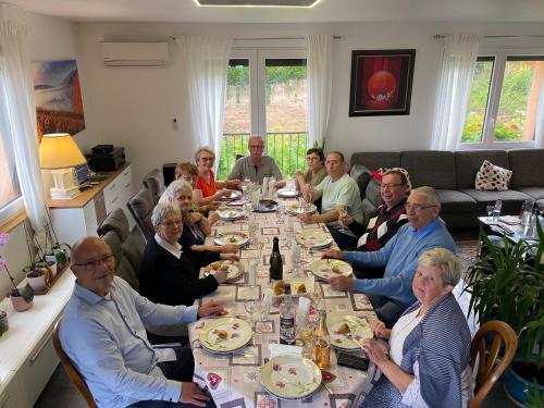 a group of people sitting around a long table eating at le chemin du meunier in Riquewihr