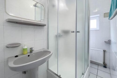 a white bathroom with a sink and a shower at Manna Villa in Balatonfüred