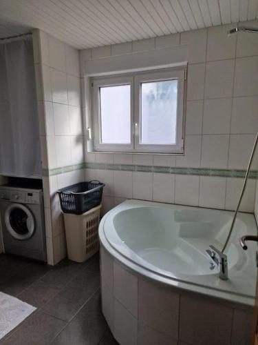 une salle de bain avec baignoire et machine à laver dans l'établissement Gîte Alsace en vue, à Hœrdt