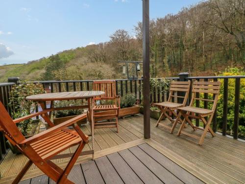 a wooden deck with two chairs and a table at 22 Two Little Ducks in Lynton