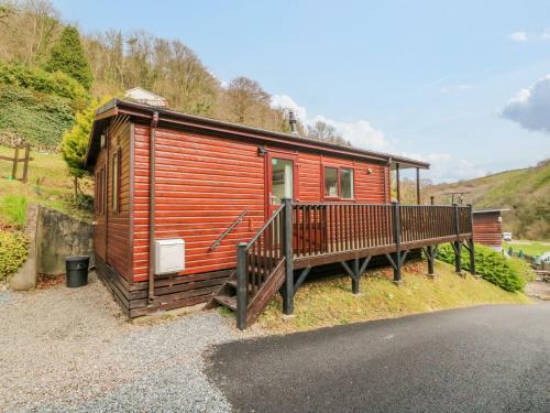 a small wooden cabin with a porch on the side of a road at 22 Two Little Ducks in Lynton