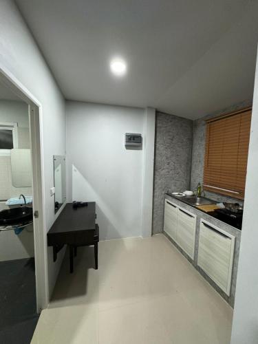 a small kitchen with a sink and a desk at Mimi Home in Ko Yao Noi