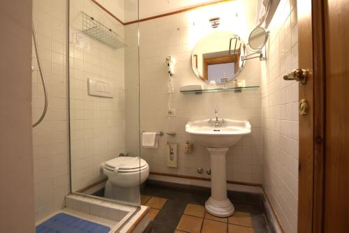 a bathroom with a toilet and a sink and a shower at Hotel Locanda Cairoli in Rome