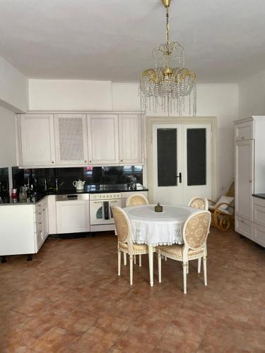 Una cocina con una mesa y sillas y una lámpara de araña. en Apartman Modrý dom, en Levoča
