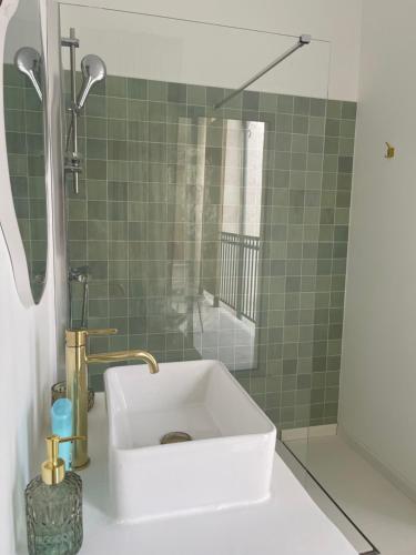 a bathroom with a white sink and a shower at Appart-Hôtel Résidence de Garonne in Tonneins