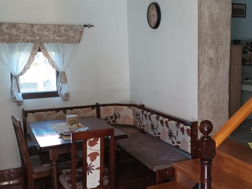 a dining room with a table and a couch and a table at Etno kuca Ostrvica 2 in Varnice