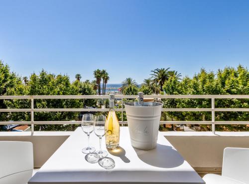 a table with wine glasses and a bucket on a balcony at Hotel Espadon bleu in Le Lavandou