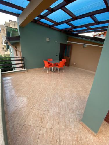 a patio with a table and chairs in a room at Vila Ajdinaj in Berat