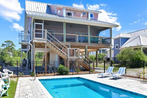a house with a swimming pool in front of a house at Turtle Town by Pristine Properties Vacation Rentals in Indian Pass