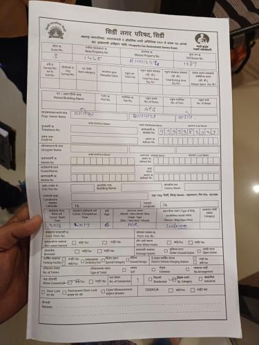 a person holding up a piece of paper at Hotel Visau,Shirdi in Shirdi