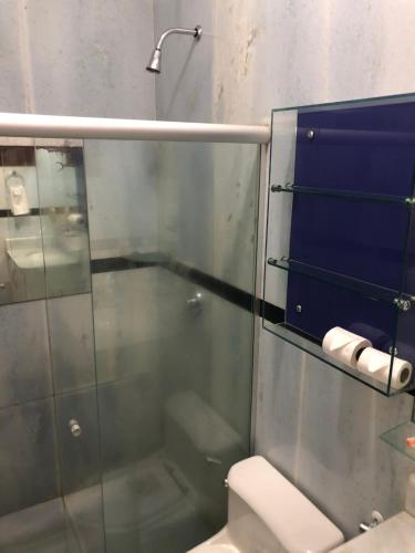 a bathroom with a shower and a toilet and towels at Hotel Mansão Marcieri in Aquiraz