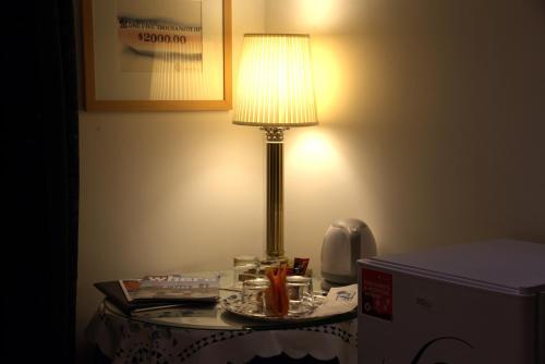 a lamp on top of a table with a phone at Hotel Locanda Cairoli in Rome