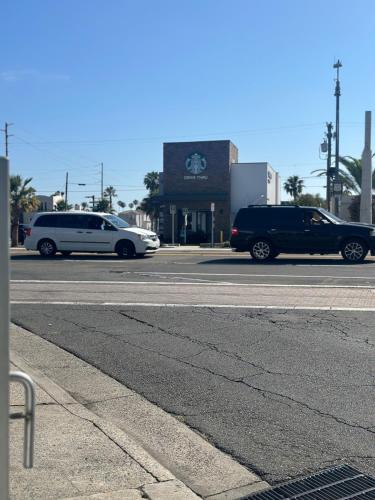 two cars parked on a street in front of a building at Super 8 by Wyndham Oceanside Downtown in Oceanside