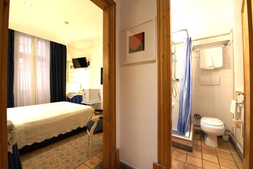 a hotel room with a bed and a toilet at Hotel Locanda Cairoli in Rome