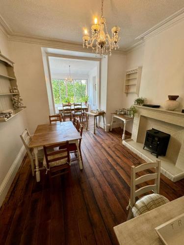 a dining room with a table and a fireplace at Fairhaven Stay in Betws-y-coed